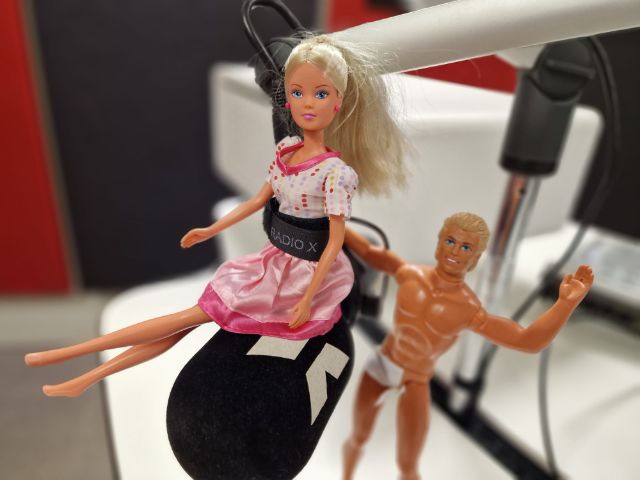 Barbie und Ken im Radio X Studio mit einem Mikrofon.